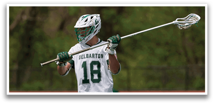 A man holding a lacrosse stick. Description generated by AI