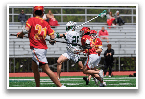 A man in a green and white uniform is running with a lacrosse stick. Description generated by AI