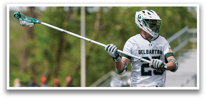 A man holding a lacrosse stick. Description generated by AI