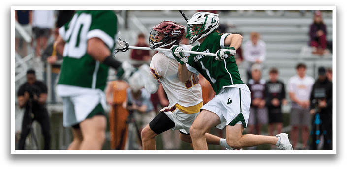 A man in a green shirt and white shorts is running with a lacrosse stick. Description generated by AI