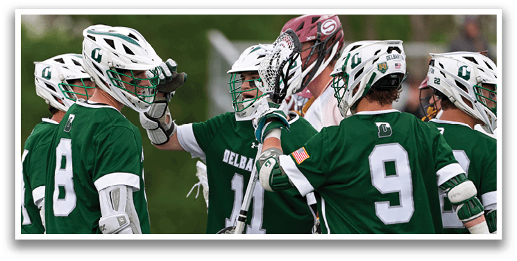 A group of men wearing green and white uniforms hugging each other. Description generated by AI