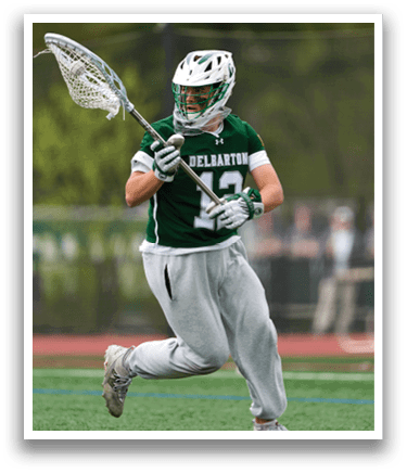 A man wearing a green and white uniform is running with a lacrosse stick. Description generated by AI
