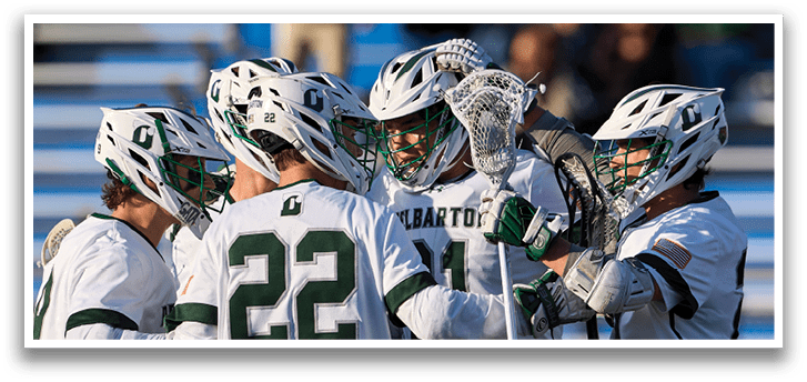 A group of lacrosse players wearing green and white uniforms. Description generated by AI