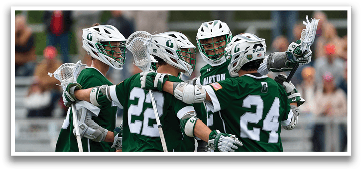A group of men wearing green and white uniforms hugging each other. Description generated by AI