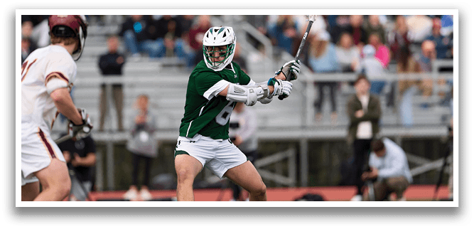 A man in a green shirt and white shorts is running with a lacrosse stick. Description generated by AI