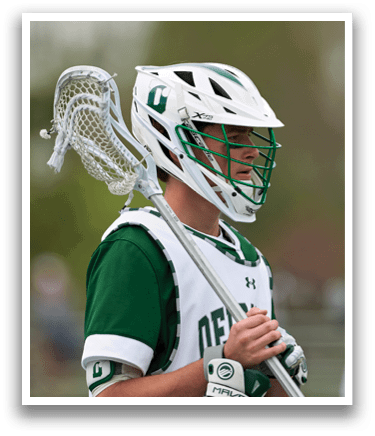 A man wearing a white and green jersey holding a lacrosse stick. Description generated by AI