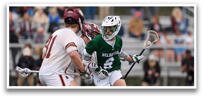 A man in a green jersey is running with a lacrosse stick. Description generated by AI