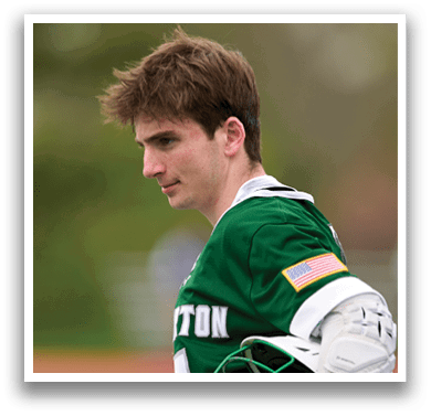 A man wearing a green and white shirt and holding a baseball glove. Description generated by AI