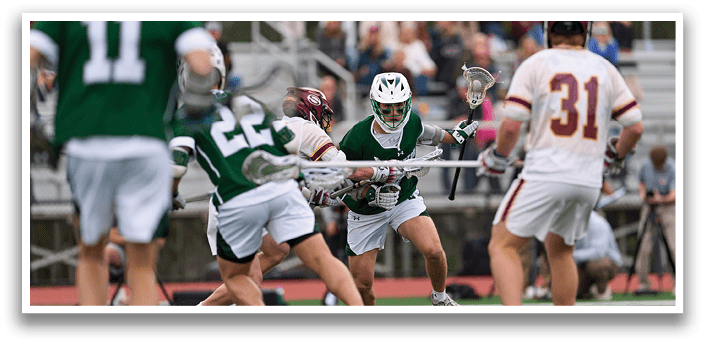 A group of men playing lacrosse on a field. Description generated by AI
