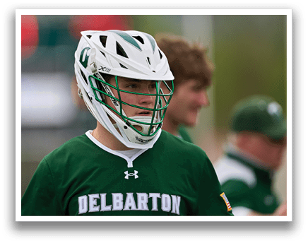 A baseball player wearing a green and white uniform with the word Delaware on the front. Description generated by AI