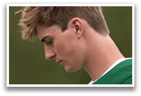 A man with blonde hair and a green shirt. Description generated by AI