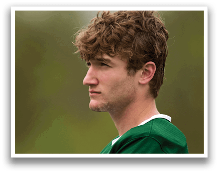 A man wearing a green and white jersey with the number 32 on it. Description generated by AI