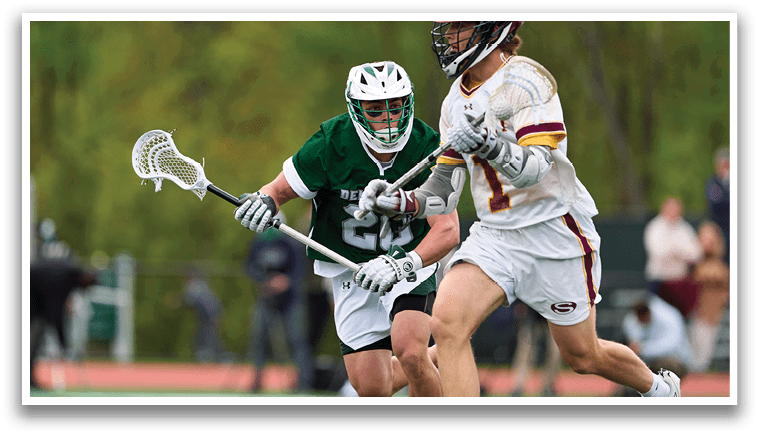 A man in a green jersey is running with a lacrosse stick. Description generated by AI