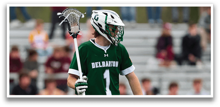 A man with a green and white uniform holding a lacrosse stick. Description generated by AI
