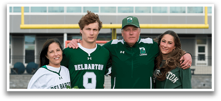 A man and woman are standing on a field with a football player in a green and white uniform. Description generated by AI
