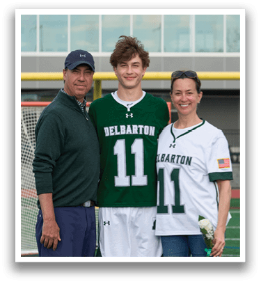 A man, woman, and boy are standing in front of a goal. Description generated by AI