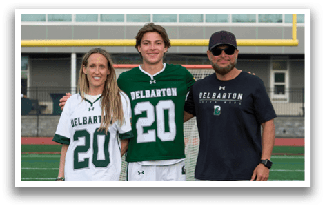 A man and woman are standing in front of a goalie. Description generated by AI