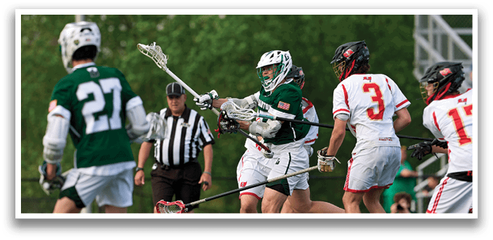 A man in a green and white uniform is holding a lacrosse stick. Description generated by AI