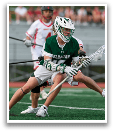 A man in a green and white uniform is holding a lacrosse stick. Description generated by AI