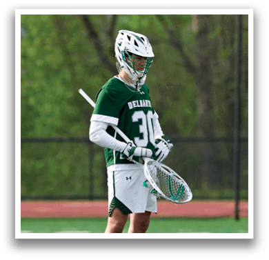 A man wearing a green and white uniform holding a baseball glove. Description generated by AI