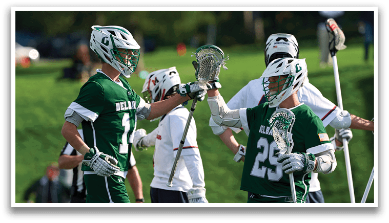 A group of men wearing green jerseys are celebrating on a field. Description generated by AI