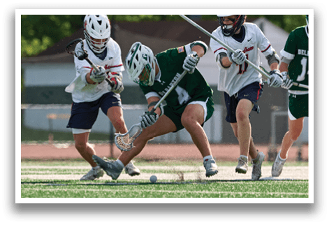 A group of men playing lacrosse on a field. Description generated by AI