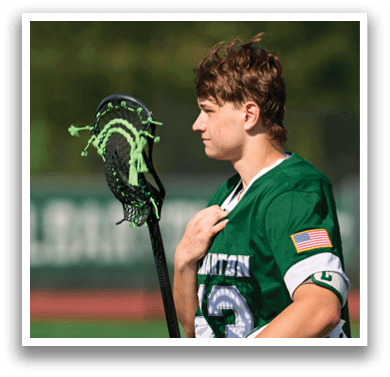 A man holding a lacrosse stick. Description generated by AI