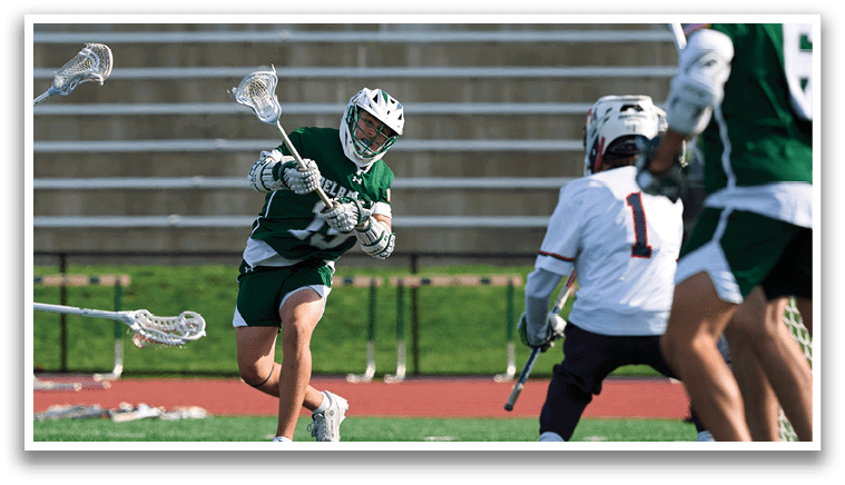 A man in a green shirt is playing lacrosse. Description generated by AI