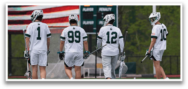 Four men wearing white uniforms and holding hockey sticks. Description generated by AI