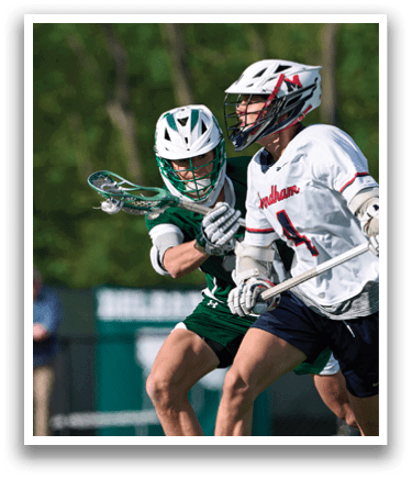 Two men playing lacrosse on a field. Description generated by AI