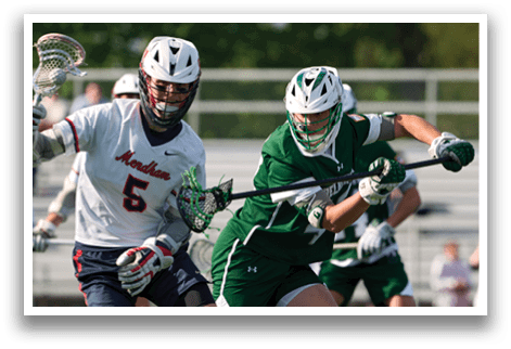 A man wearing a green shirt and white shorts is holding a lacrosse stick. Description generated by AI