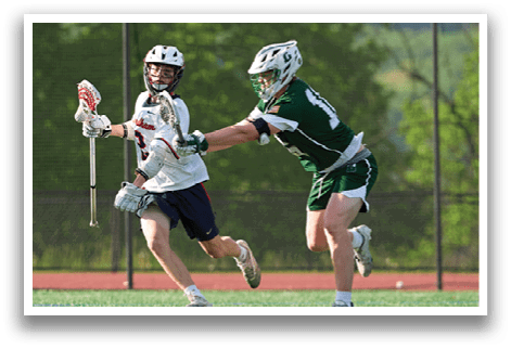 A boy in a white shirt and blue shorts is running with a lacrosse stick. Description generated by AI