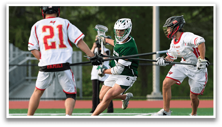 A man in a green shirt is holding a lacrosse stick. Description generated by AI
