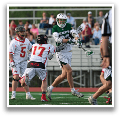 A man in a green and white uniform is holding a lacrosse stick. Description generated by AI