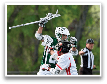 A man in a green shirt and white shorts is holding a lacrosse stick. Description generated by AI