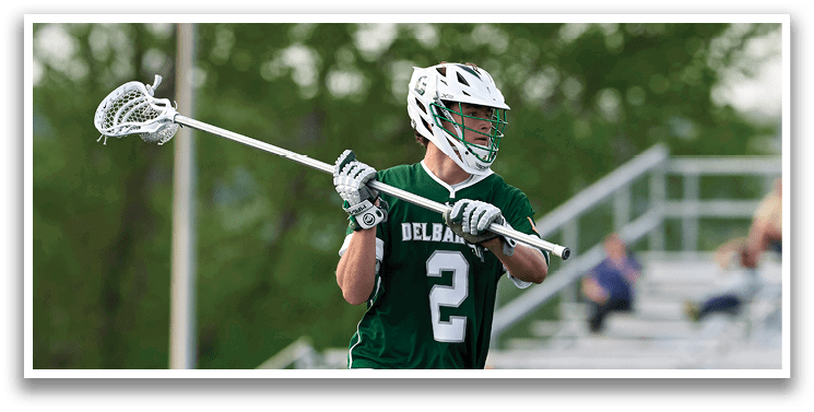 A man holding a lacrosse stick. Description generated by AI