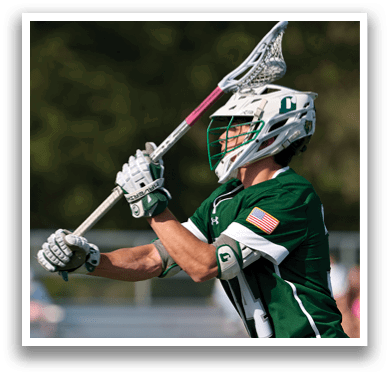 A man wearing a green and white shirt and holding a lacrosse stick. Description generated by AI