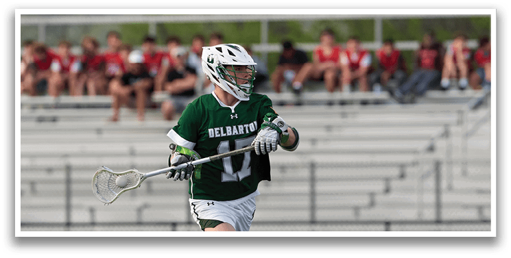 A man wearing a green and white jersey is running on a field. Description generated by AI