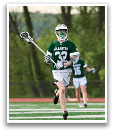 A man in a green and white uniform is running on a field. Description generated by AI
