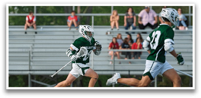 A man in a green and white uniform is running on a field. Description generated by AI