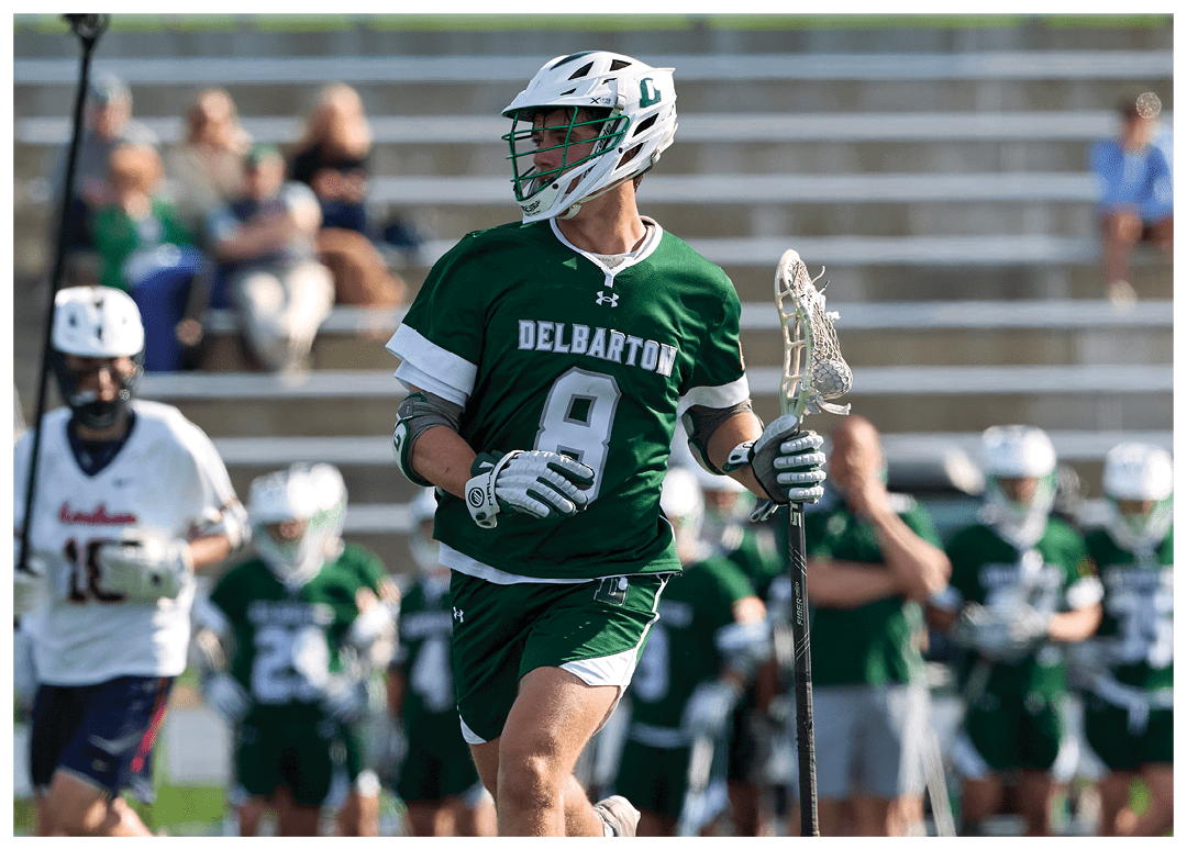 A man wearing a green and white uniform is running on a field. Description generated by AI
