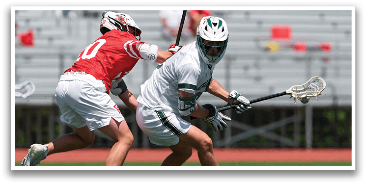 A man in a white shirt and green shorts is running with a lacrosse stick. Description generated by AI
