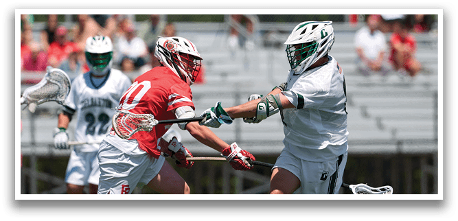 A man in a red jersey is running on a field with a lacrosse stick. Description generated by AI