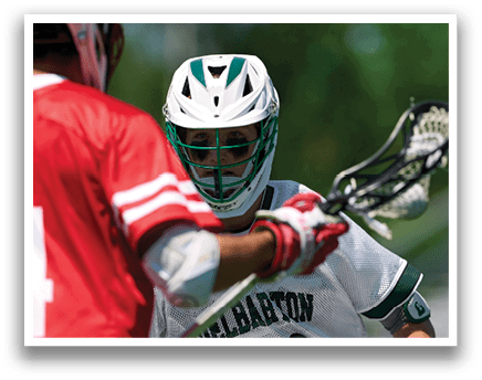 Two men wearing red and white shirts are playing lacrosse. Description generated by AI