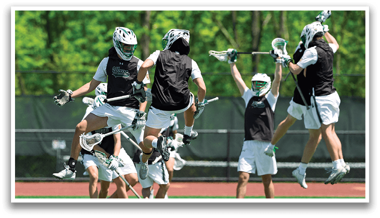A group of men playing lacrosse on a field. Description generated by AI