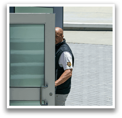 A man is walking past a glass door. Description generated by AI