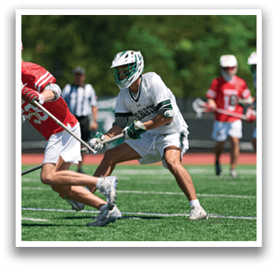 A man in a red jersey is holding a lacrosse stick. Description generated by AI