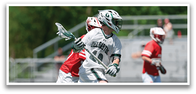 A man running on a field with a white and green shirt and a red helmet. Description generated by AI