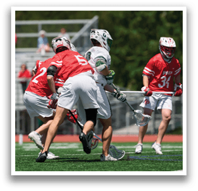A group of men playing lacrosse on a field. Description generated by AI