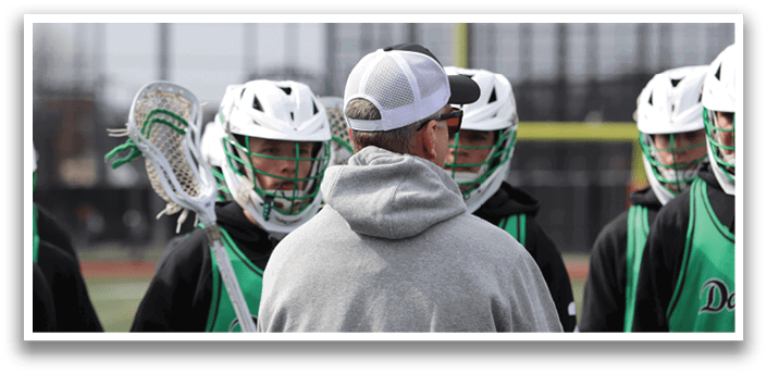 A group of lacrosse players wearing green and white uniforms are gathered around a man in a grey hoodie. AI generated content